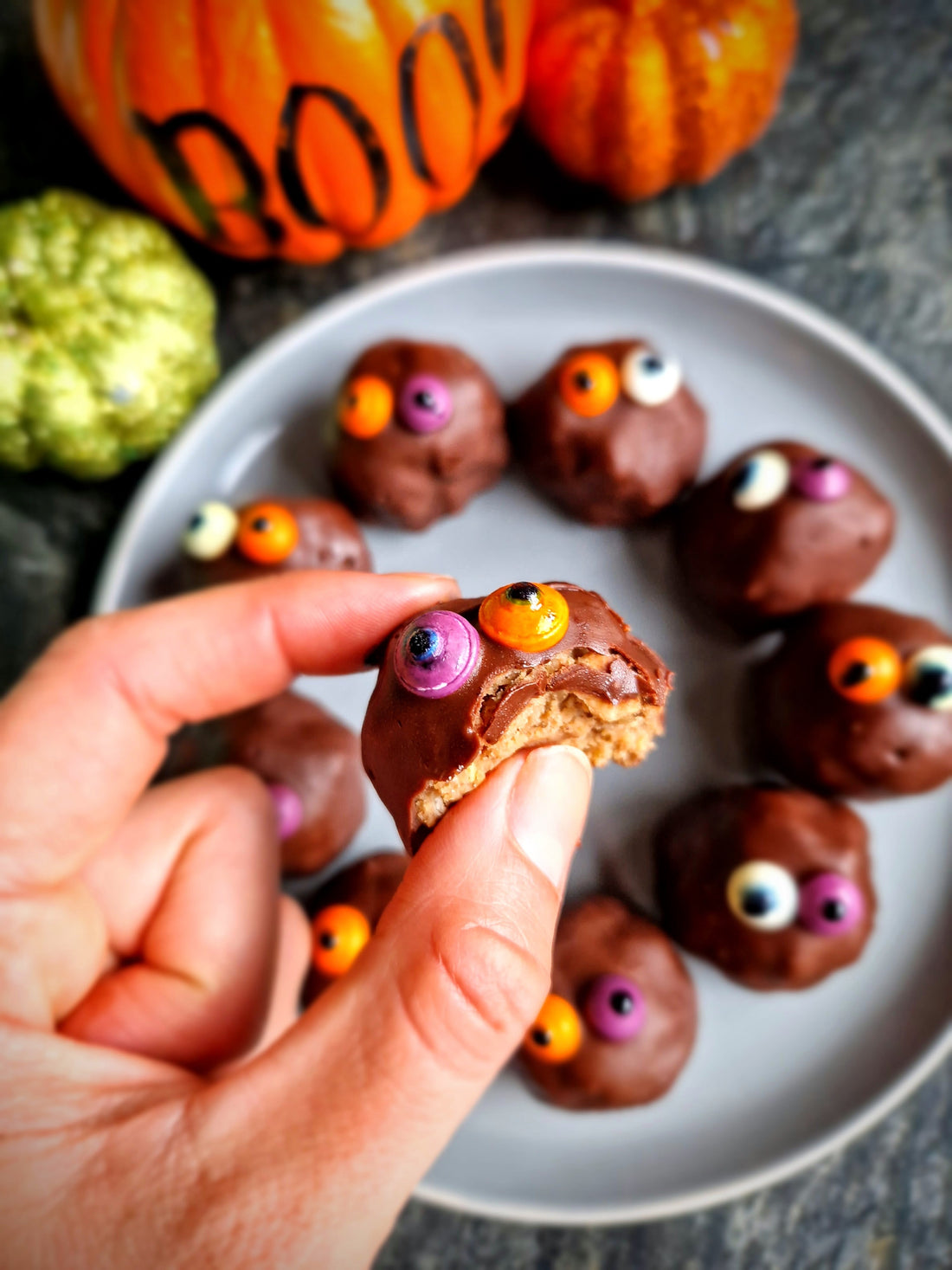 Spooky Halloween Protein Balls dipped in dark chocolate with edible eyes.