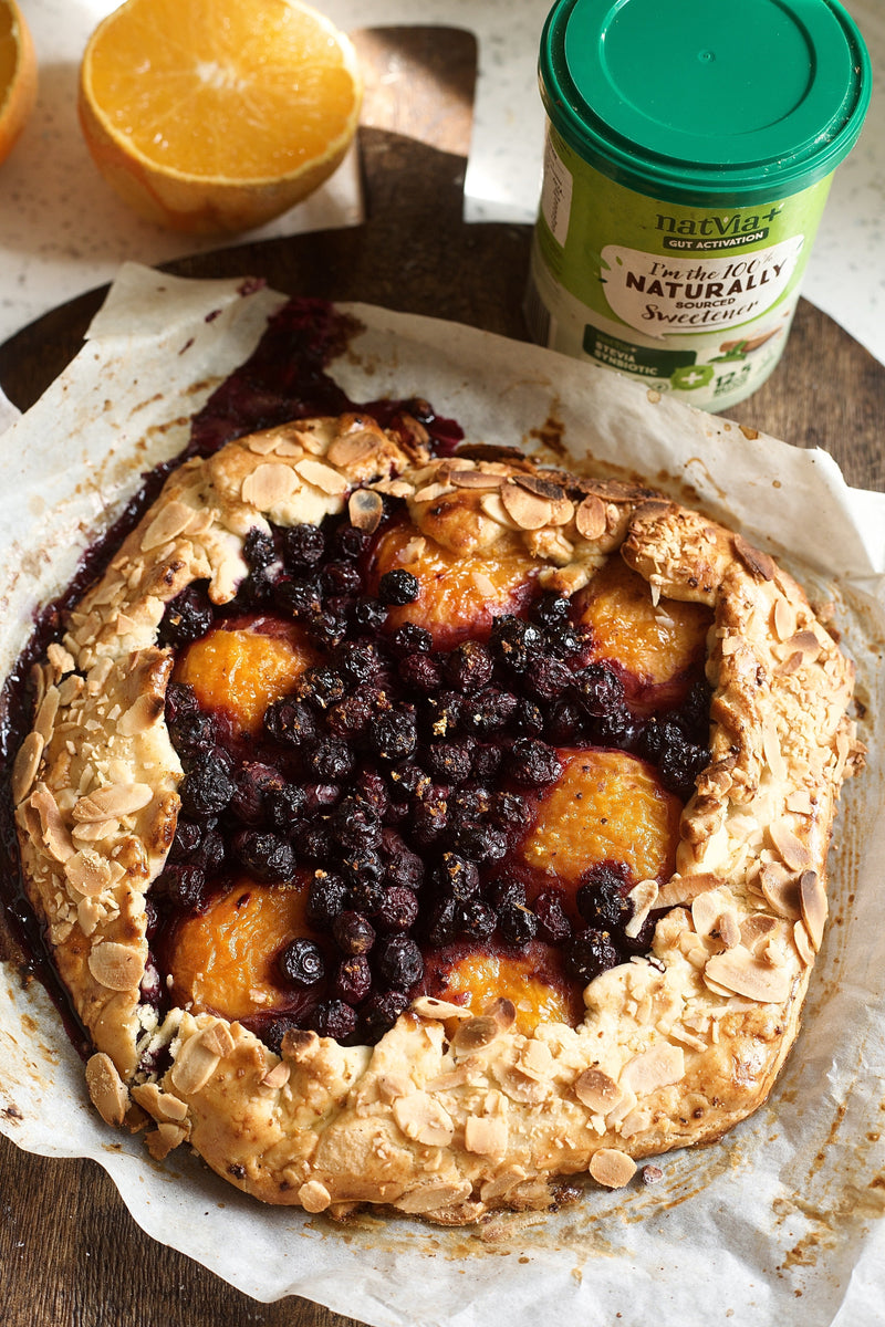 One big Cardamom Blueberry & Apricot Rustic Galette serving. Alongside natvia natural sweetener and an orange on the side. 