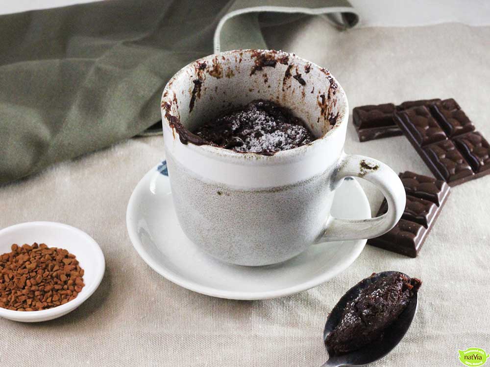 chocolate molten lava cake in a white mug with chocolate pieces and coffee