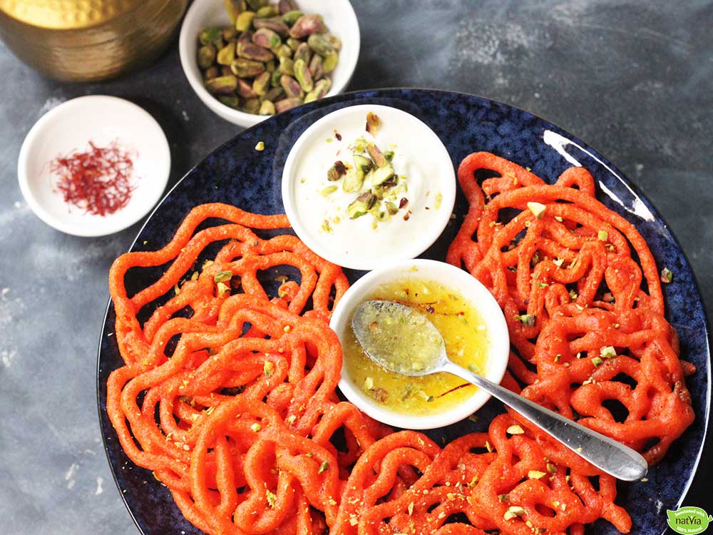jalebi on plate with syrup and pistachios