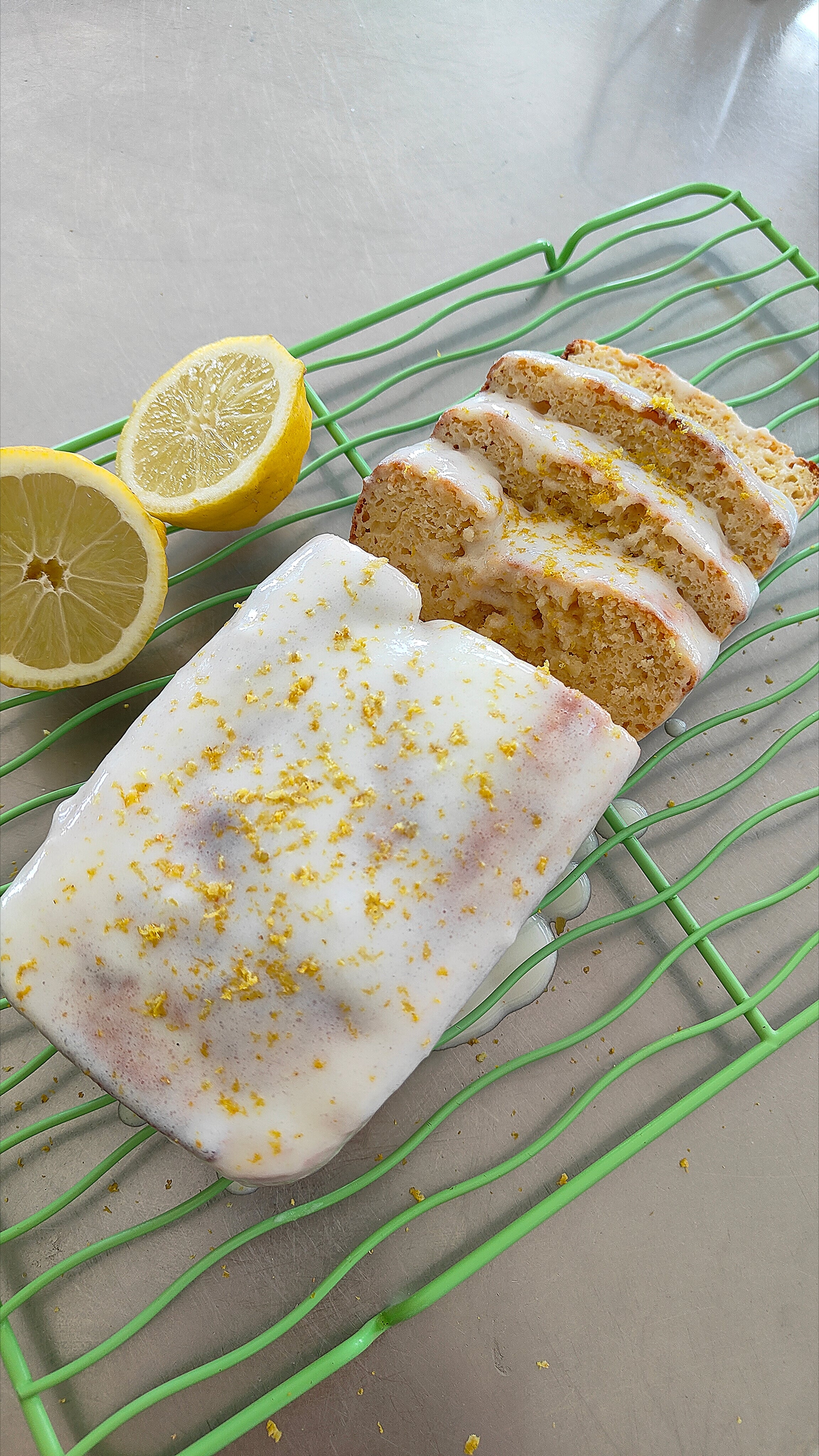 Slice of moist Spring Lemon Drizzle Loaf topped with lemon drizzle icing, made with Greek yogurt and Natvia natural sweetener