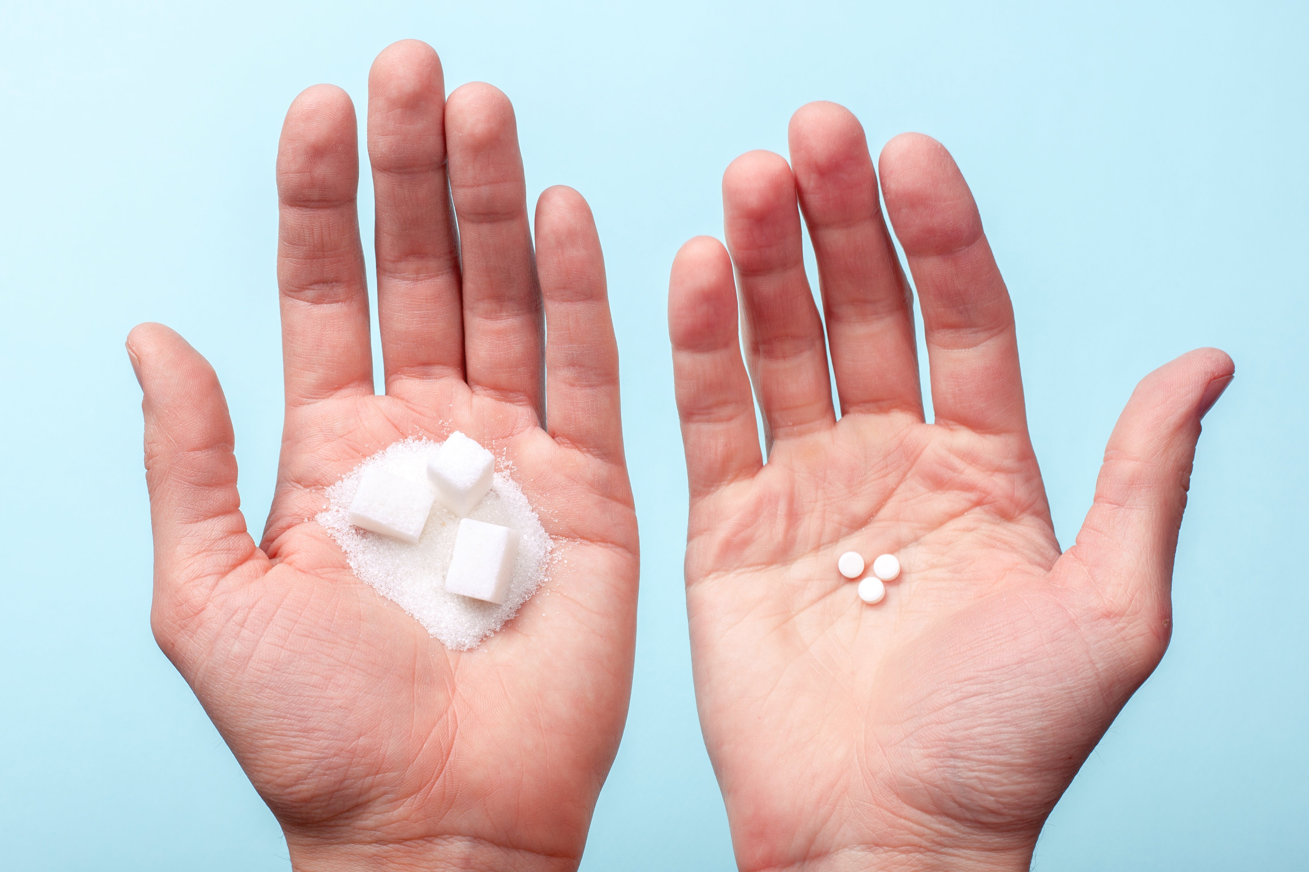 Hands with sugar and sweetener