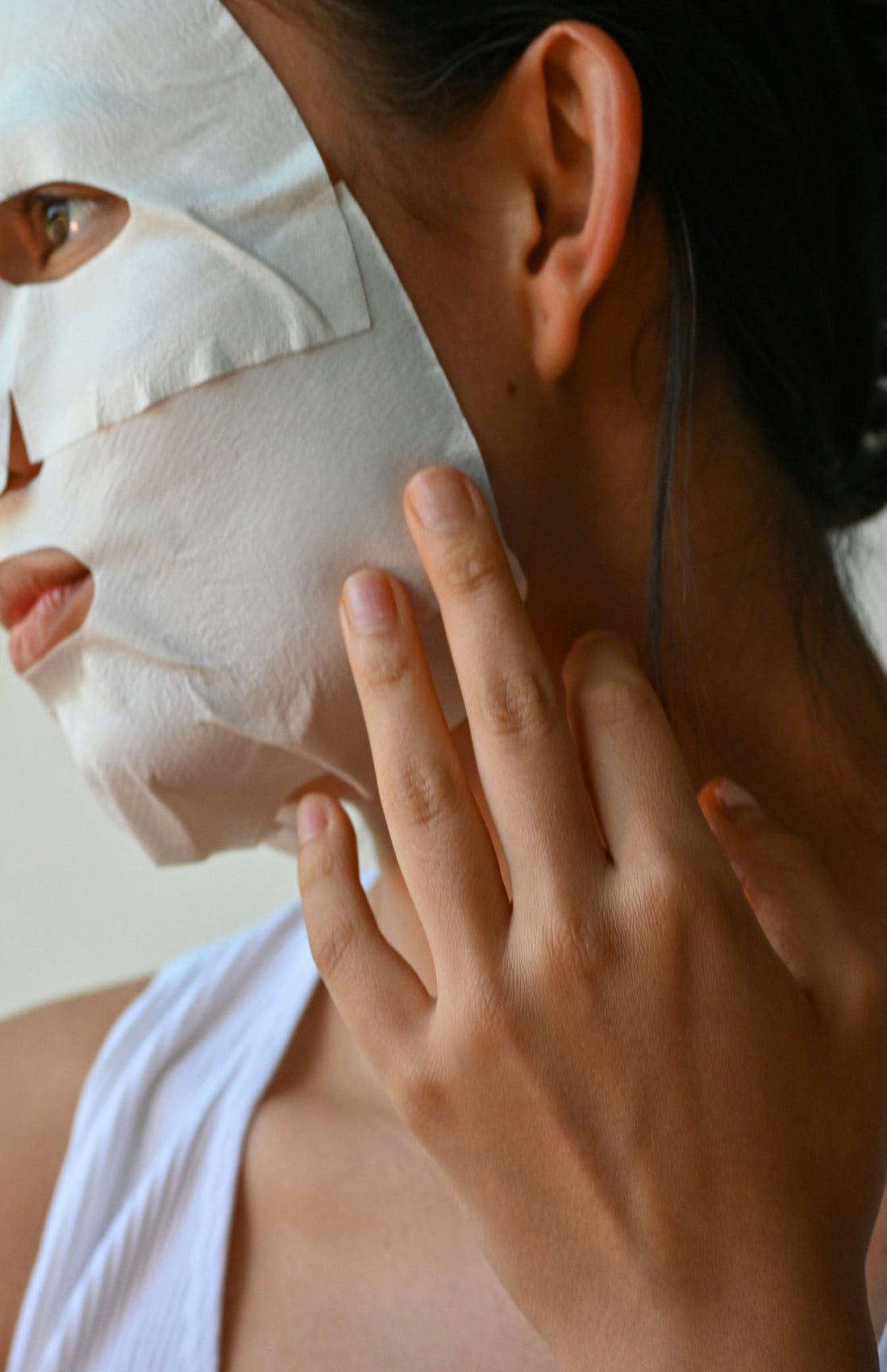 Woman taking care of her skin with a sheet facemask