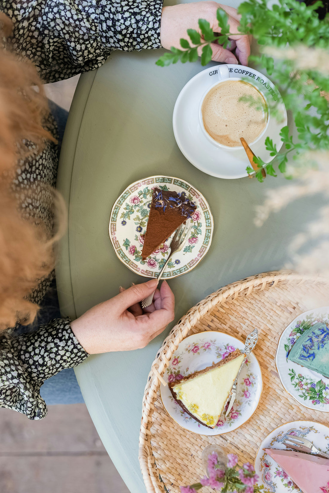 A woman is enjoying a morning coffee with a slice of chocolate cake, surrounded by three other slices of sugar-free cake